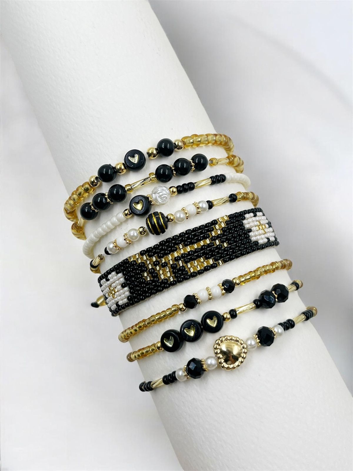 Maxipulsera Flor Dorada compuesta por ocho vueltas con tejido artesanal, corazones y detalles decorativos.