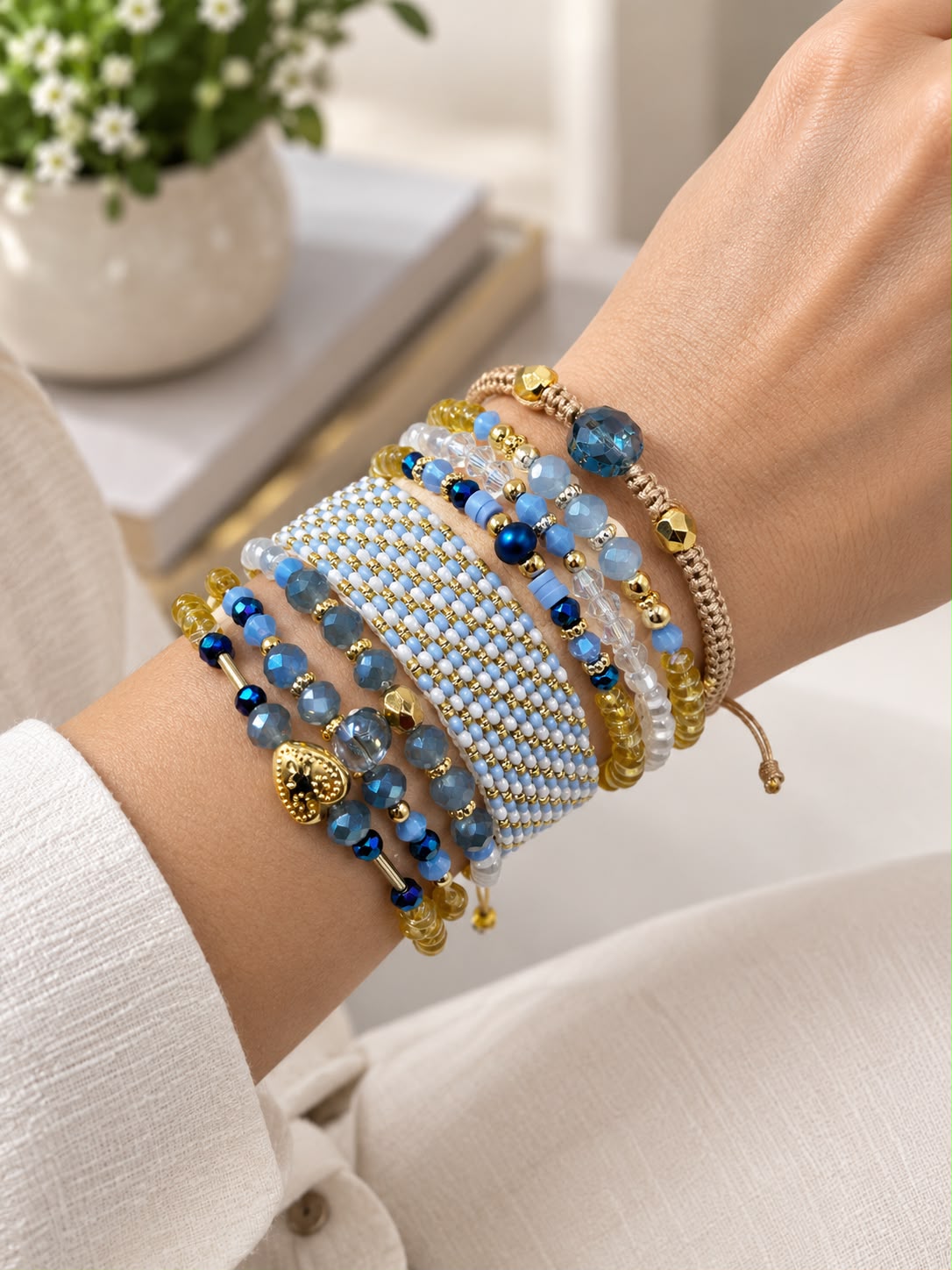 Maxipulsera de 8 vueltas con banda central tejida, cuentas facetadas, esferas de diferentes tamaños, detalles geométricos y dije de corazón.