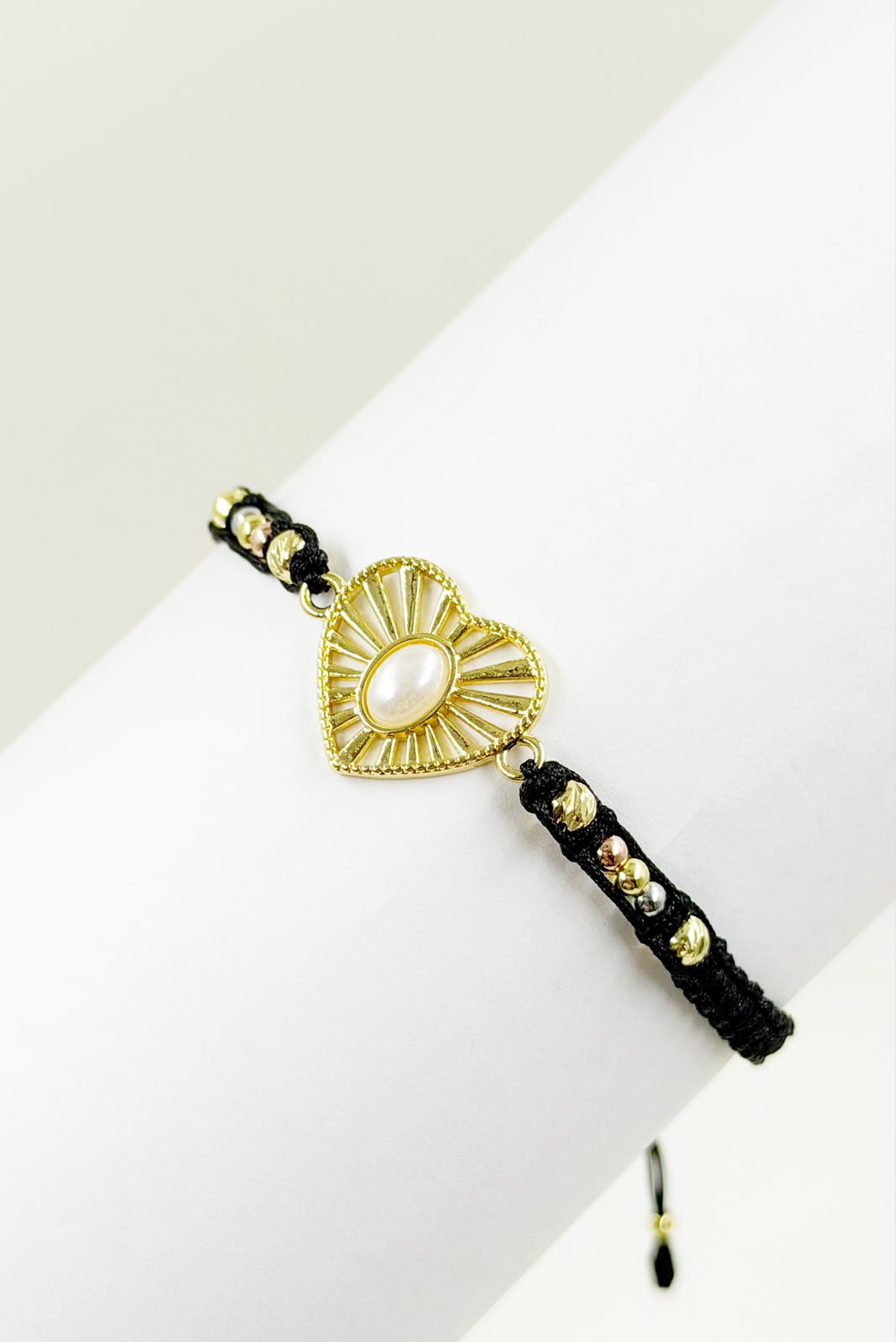 Pulsera artesanal con diseño de corazón calado y detalle central, de estilo delicado y romántico.