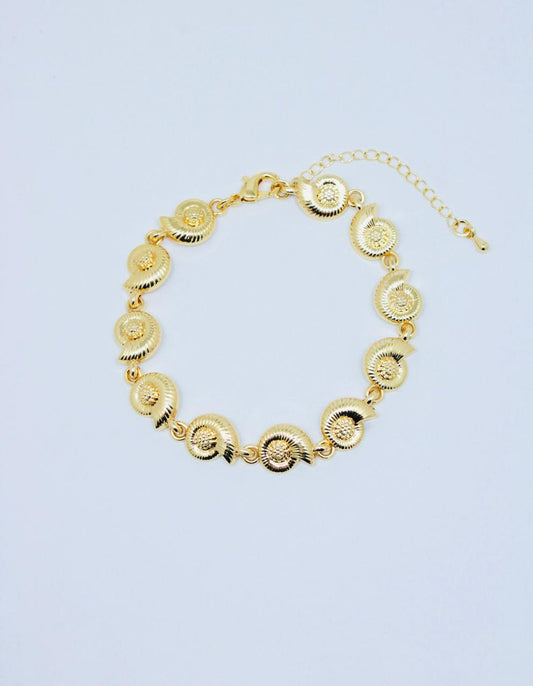 Pulsera Caracol Diamante de 17 cm con dijes de caracoles dorados enlazados, broche pico de loro y extensión ajustable.