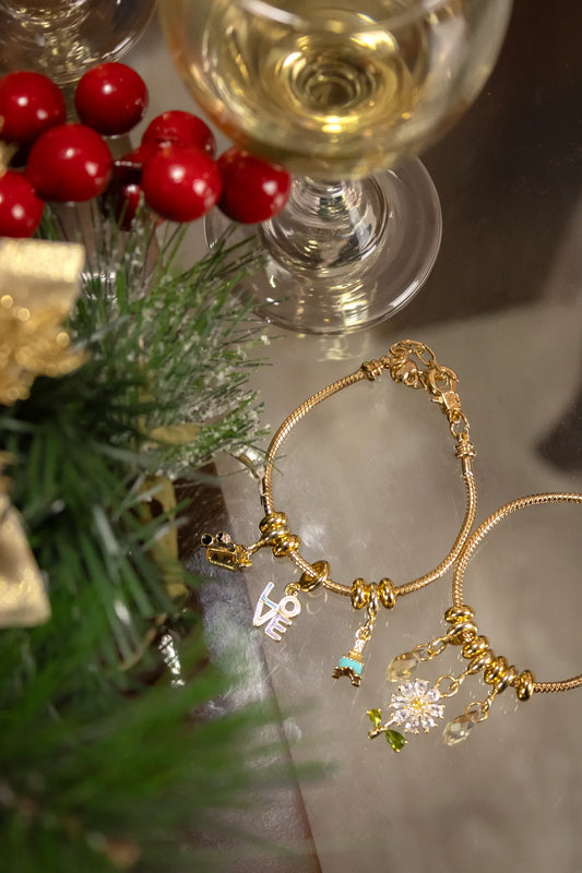 Pulsera Charms Torre Love en guaya dorada con dijes rodinados pintados y lacados.