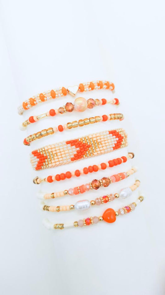 Pulsera Aura 8 con ocho vueltas artesanales, chaquiras blancas y doradas, muranos, y dije de corazón dorado.