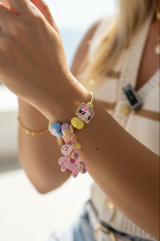 Pulsera de guaya dorada con dijes de resina y dije de pony que brilla en la oscuridad
