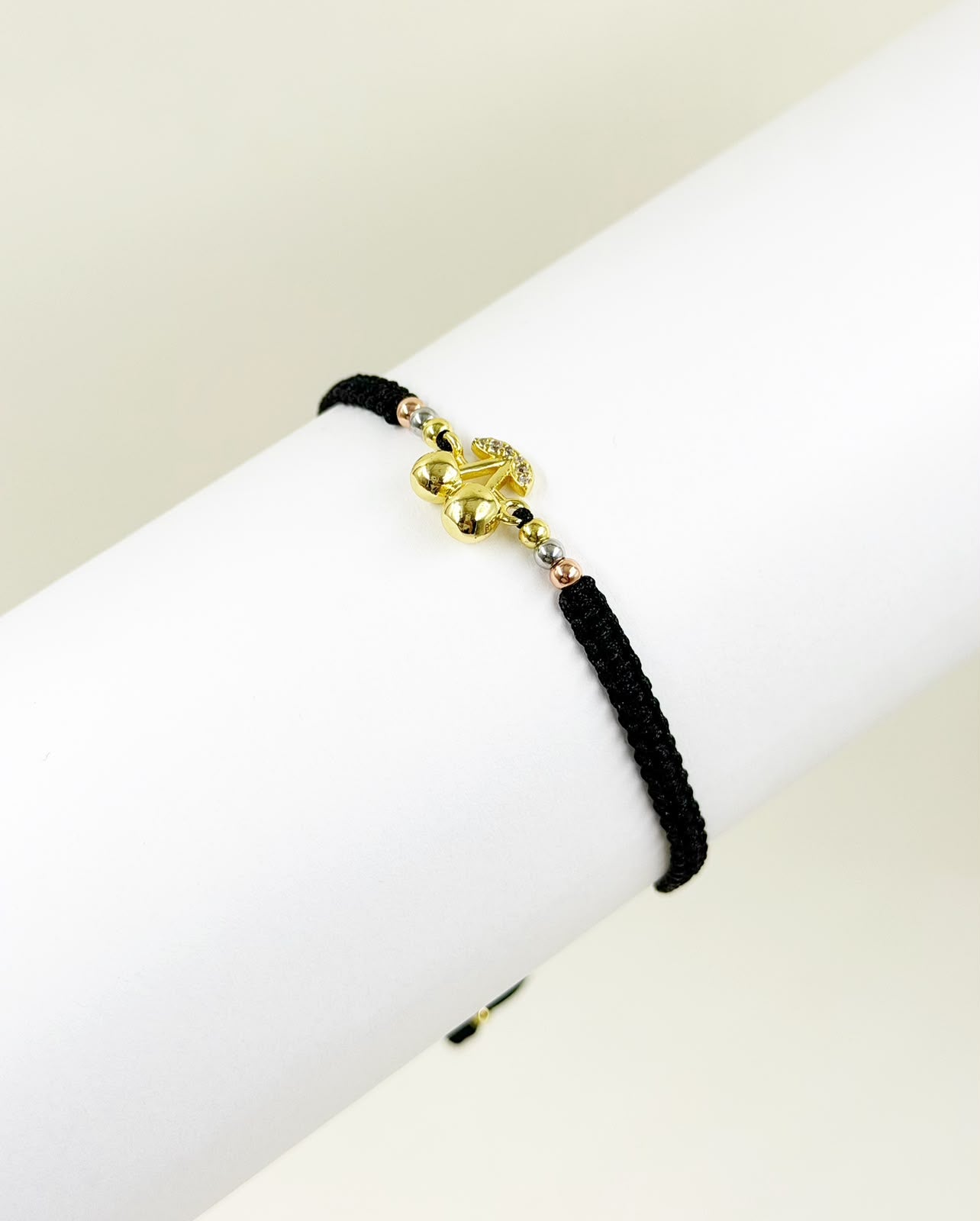 Pulsera elegante con dije en forma de cereza sobre fondo neutro