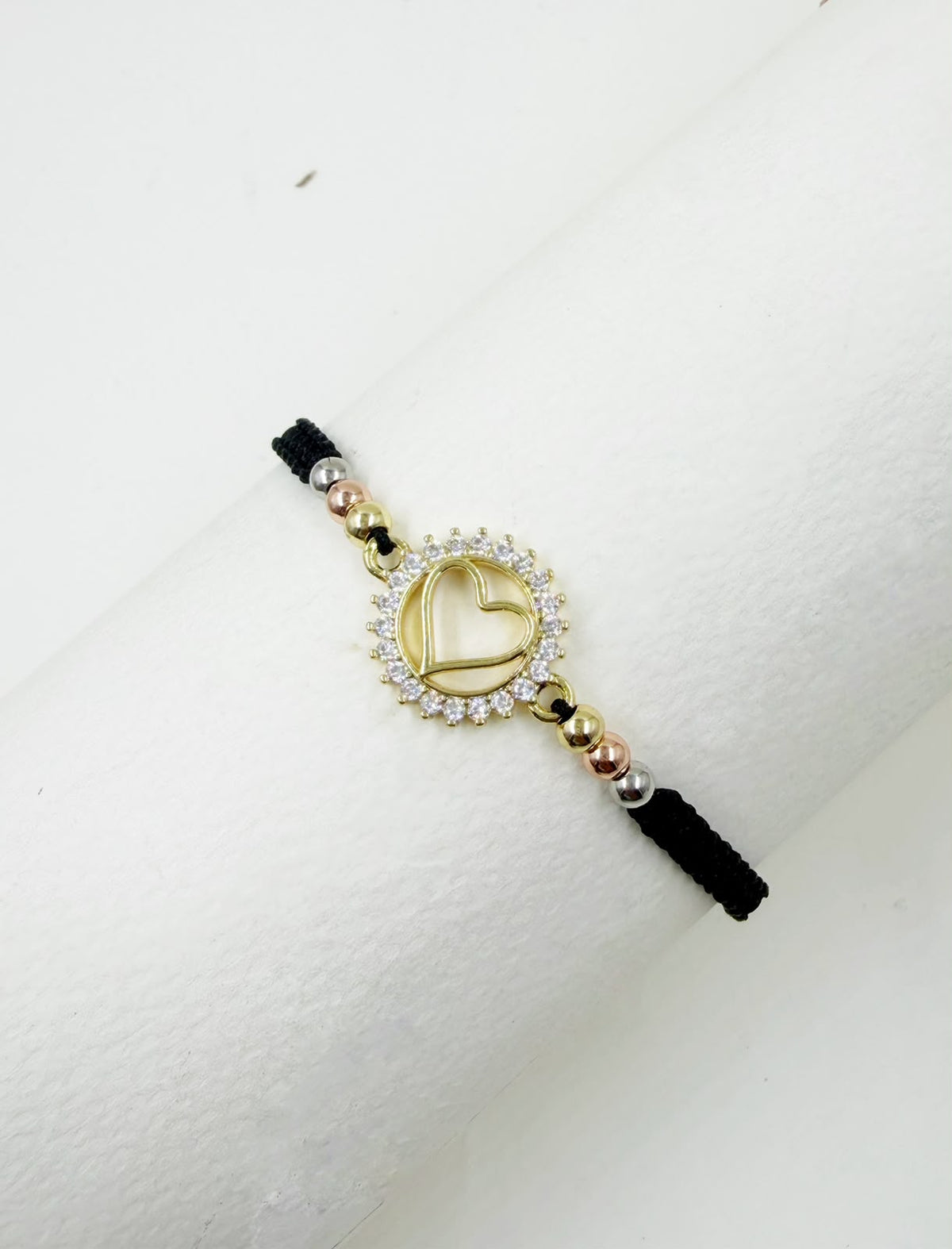 Pulsera artesanal con dije de corazón calado y detalles brillantes, de diseño delicado y romántico.