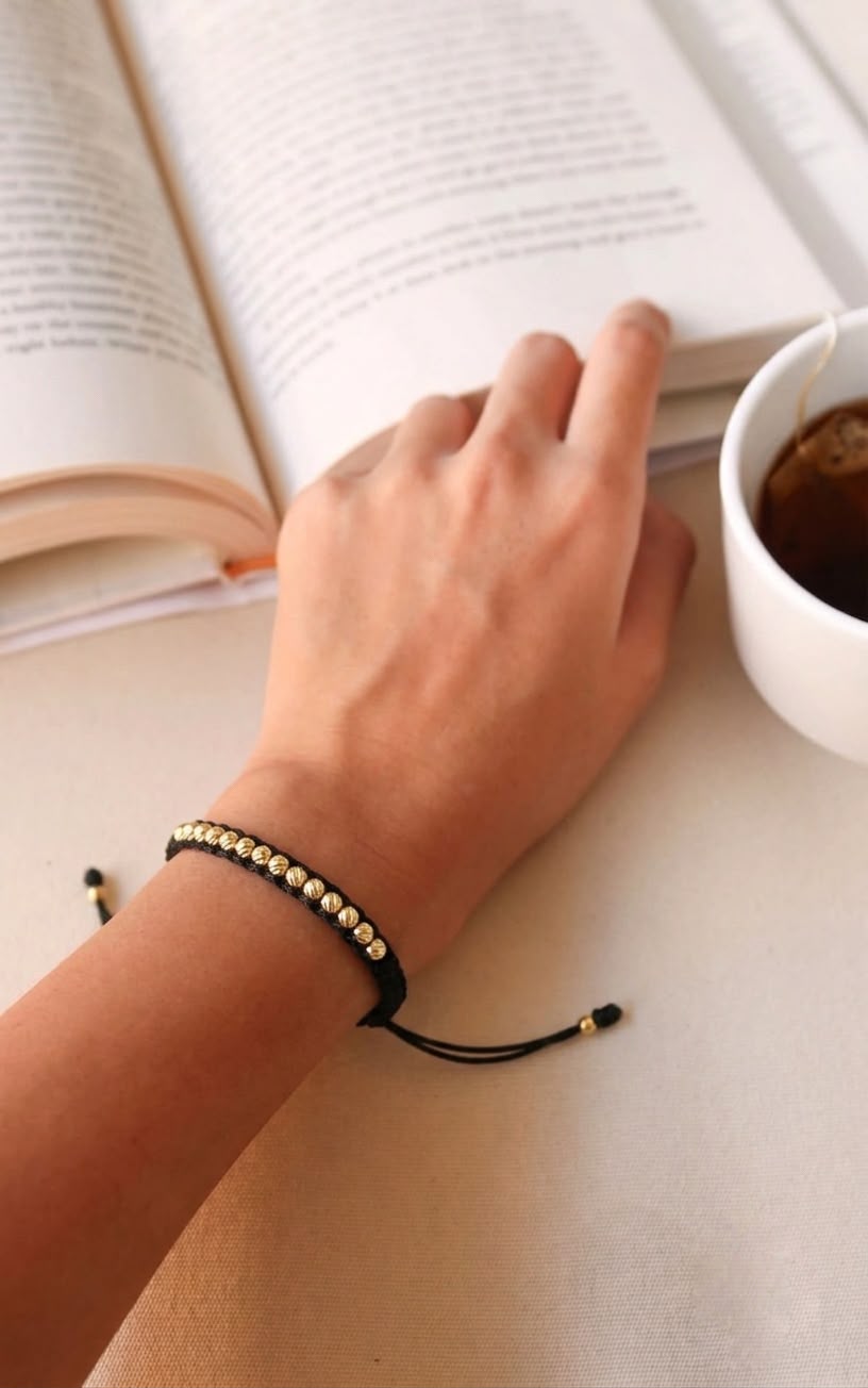 Pulsera artesanal de diseño minimalista con detalles decorativos en los extremos.