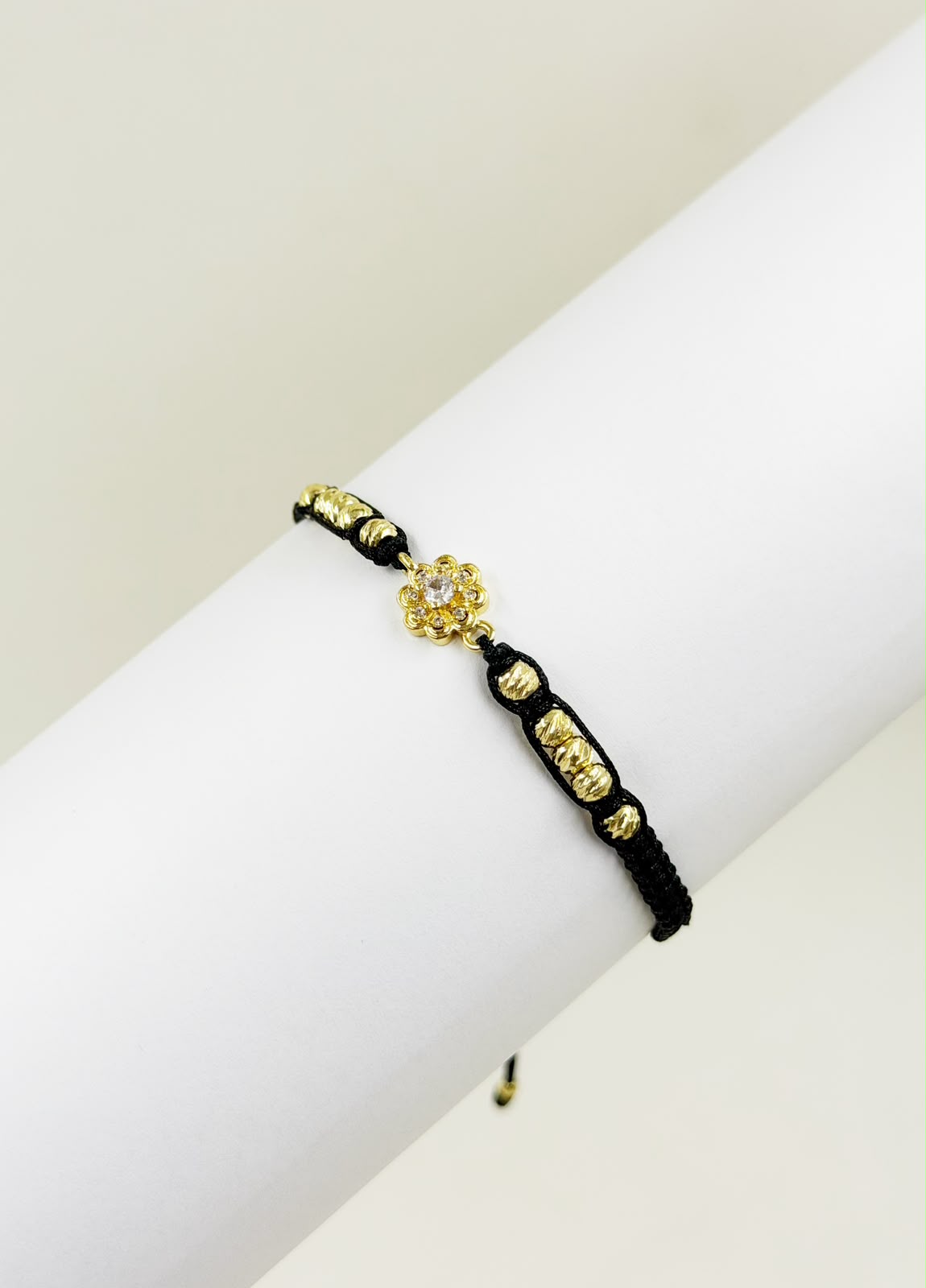 Pulsera artesanal con dije de flor, de diseño delicado, femenino y elegante.