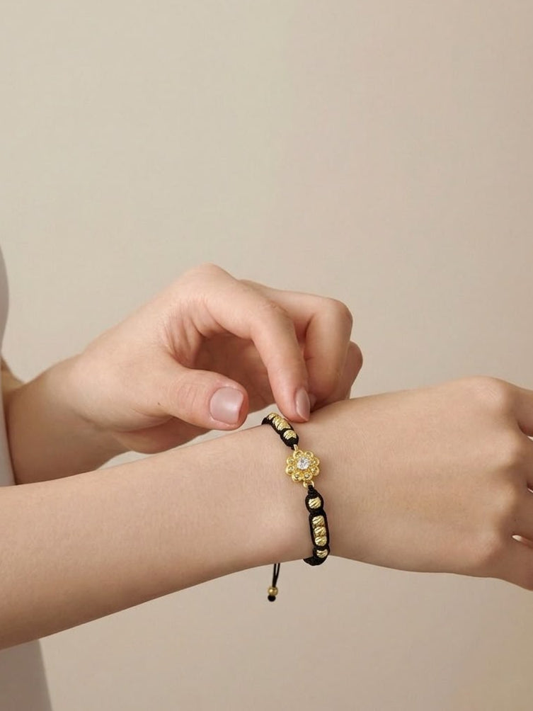 Pulsera artesanal con dije de flor, de diseño delicado, femenino y elegante.