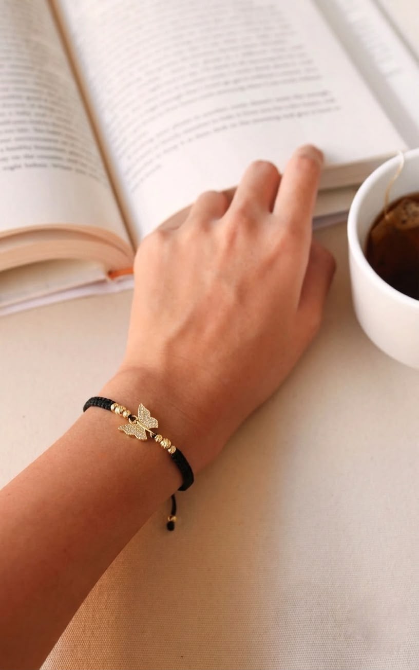Pulsera artesanal con dije de mariposa, de diseño delicado y elegante.