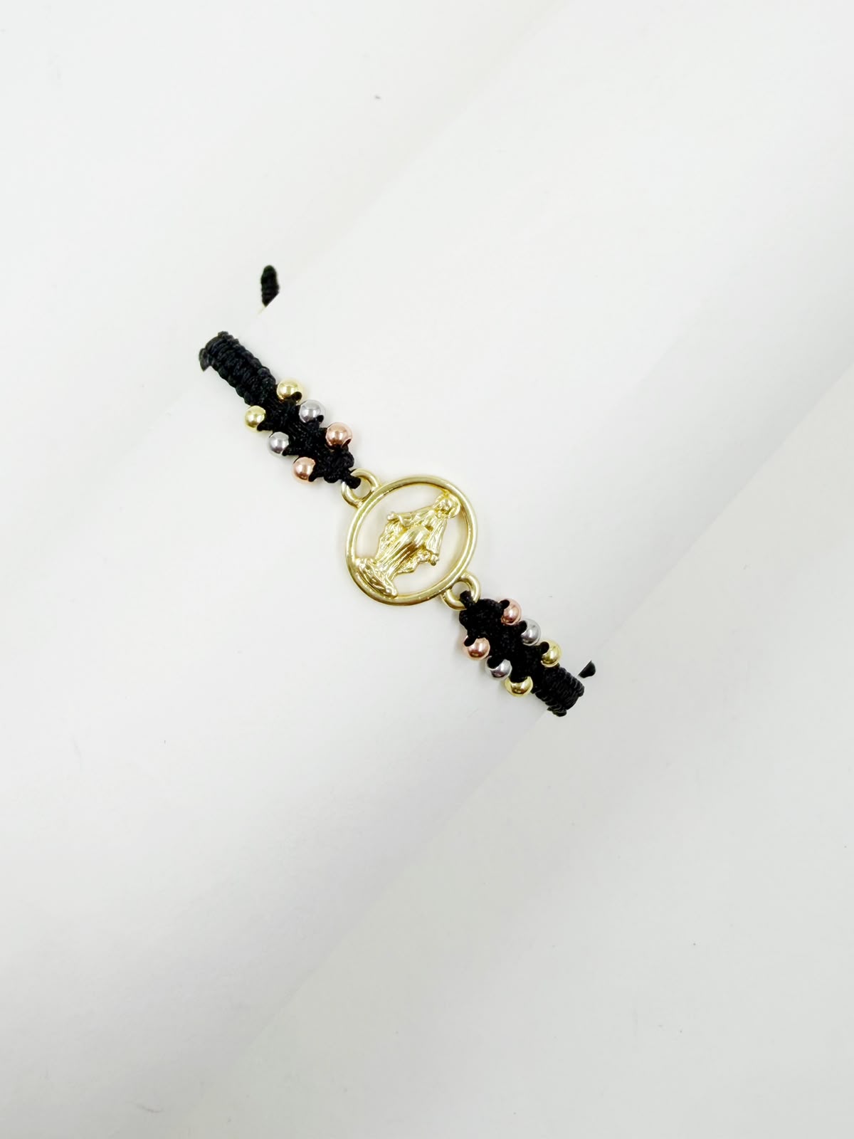 Pulsera artesanal con dije de la Virgen de la Milagrosa, de diseño calado y delicado.
