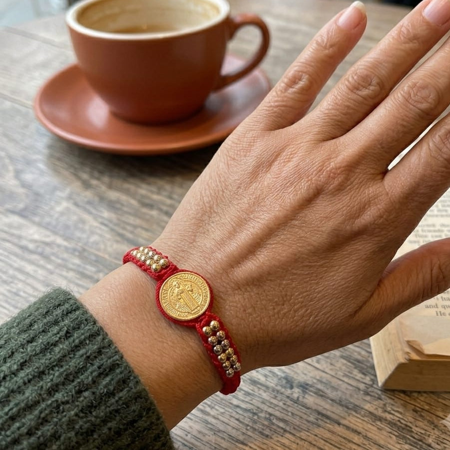 Pulsera artesanal con dije de San Benito y diseño delicado de estilo simbólico.