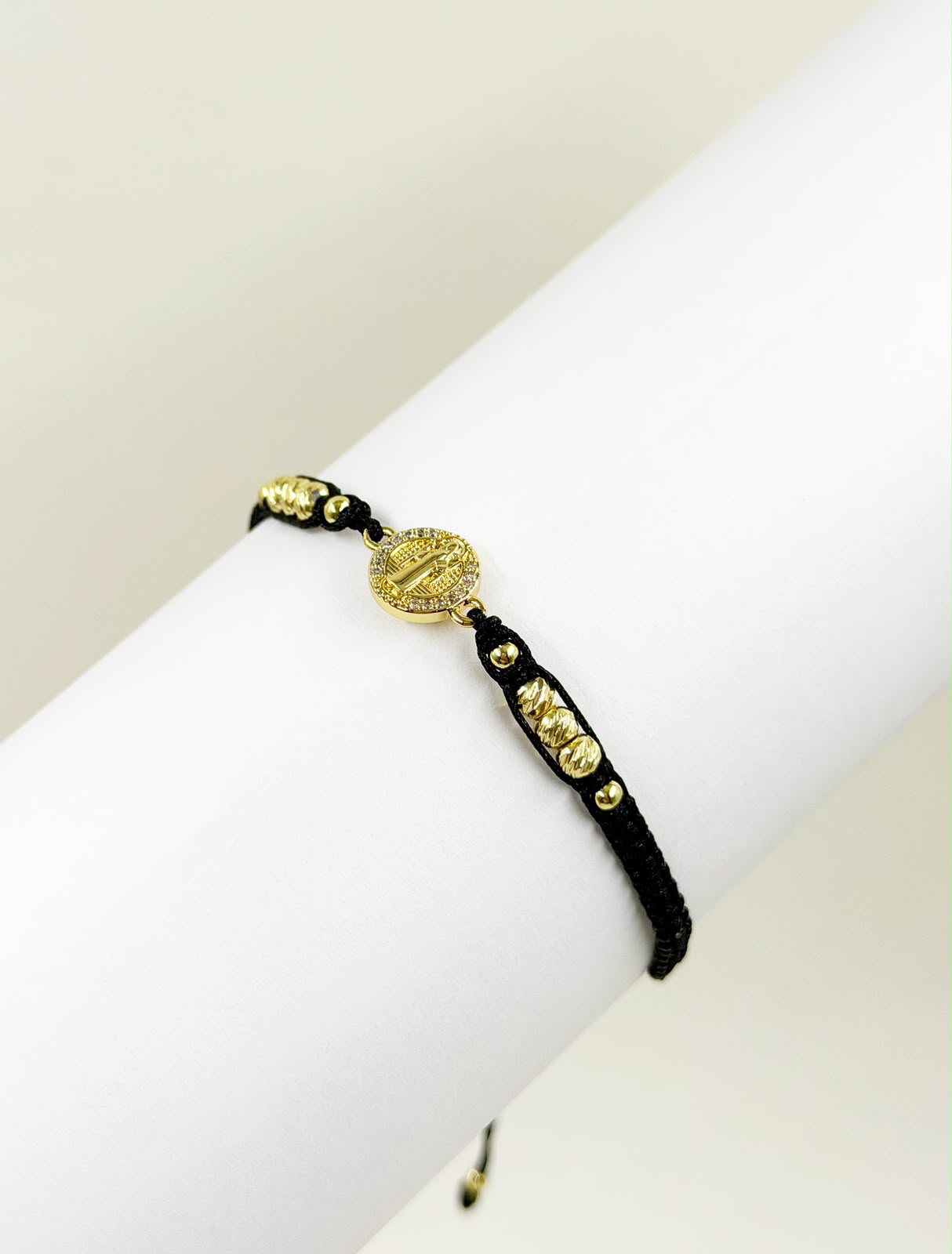Pulsera artesanal con dije de San Benito, de diseño sencillo, delicado y elegante.