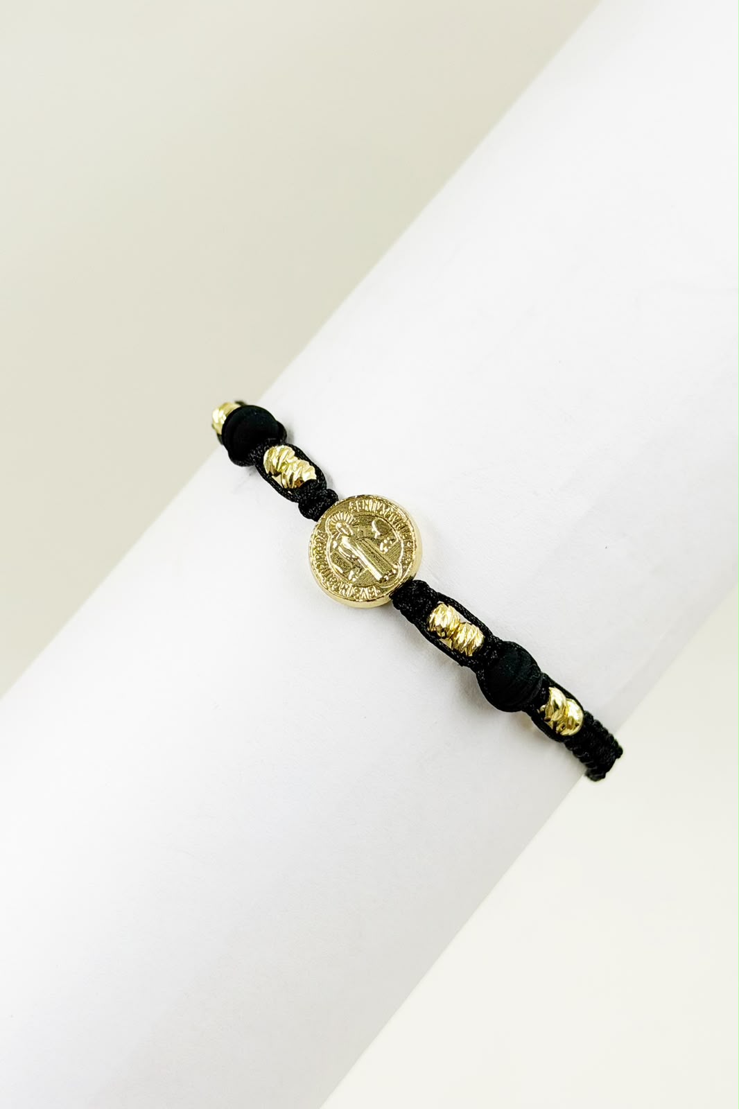 Pulsera artesanal sencilla con dije de San Benito y diseño minimalista.