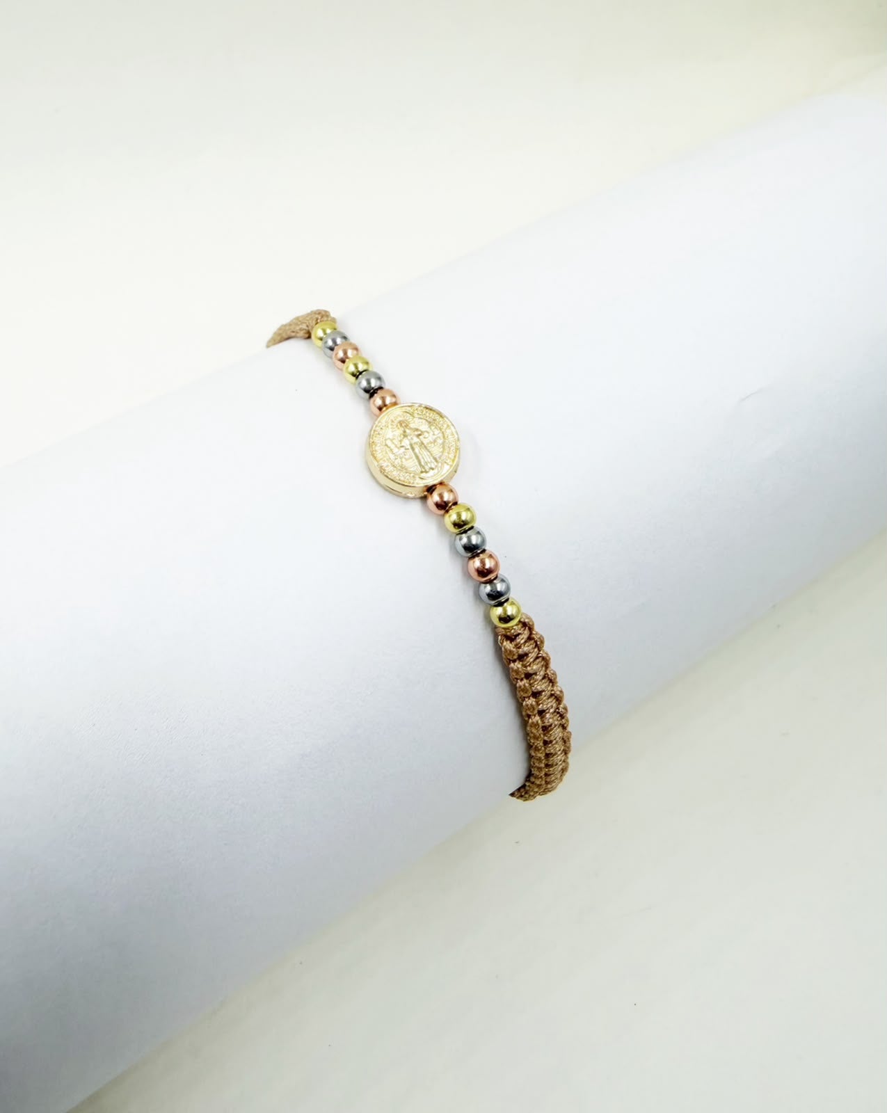 Pulsera artesanal con dije de San Benito, de diseño delicado y elegante.