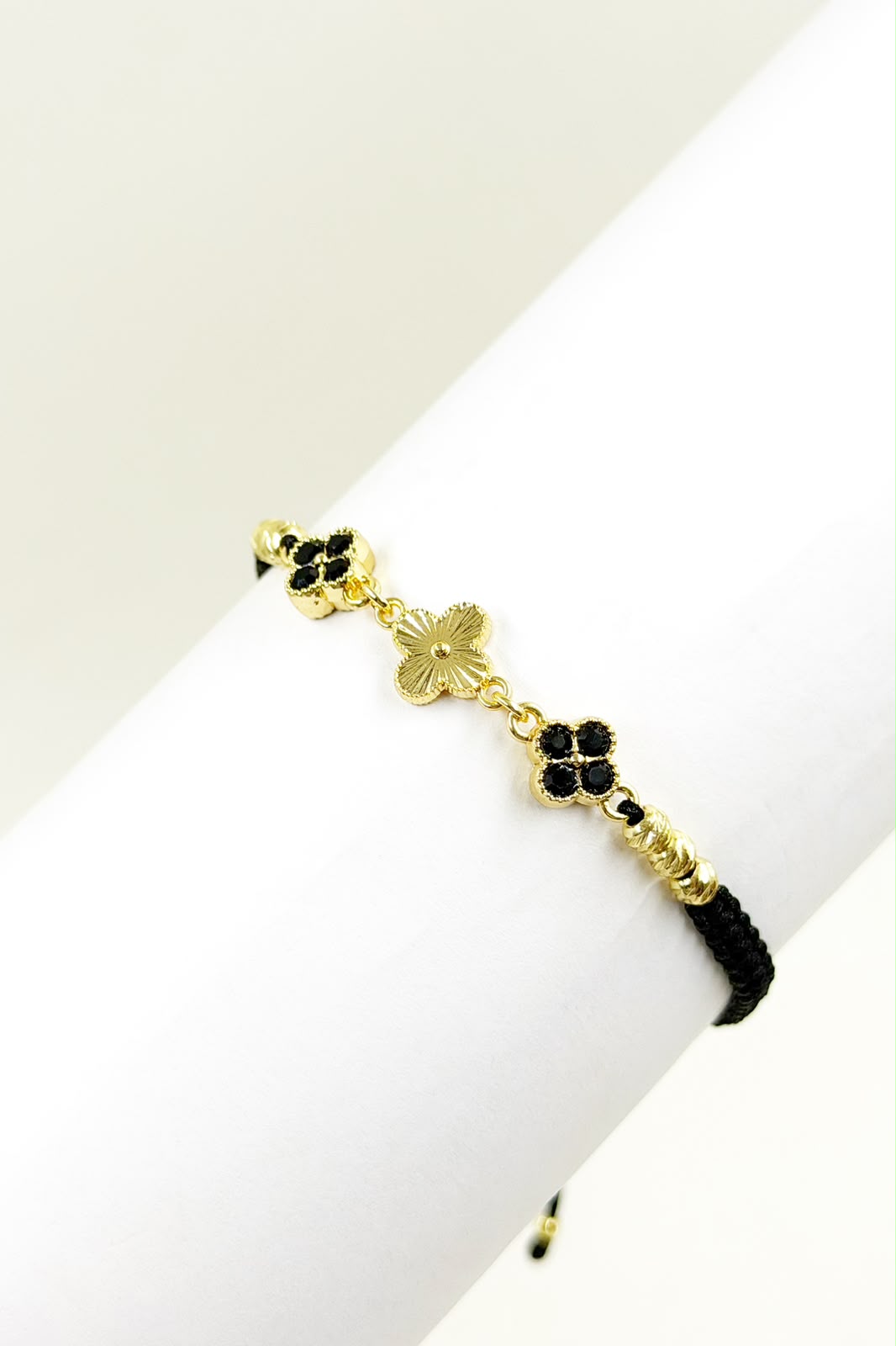 Pulsera artesanal con tres tréboles de cuatro hojas y diseño delicado.