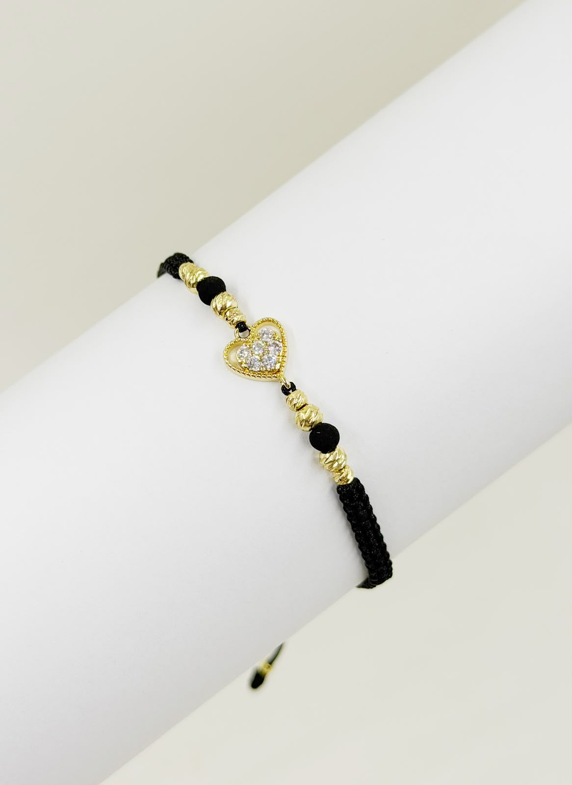 Pulsera artesanal con dije de corazón decorado con detalles brillantes, de diseño delicado y romántico.