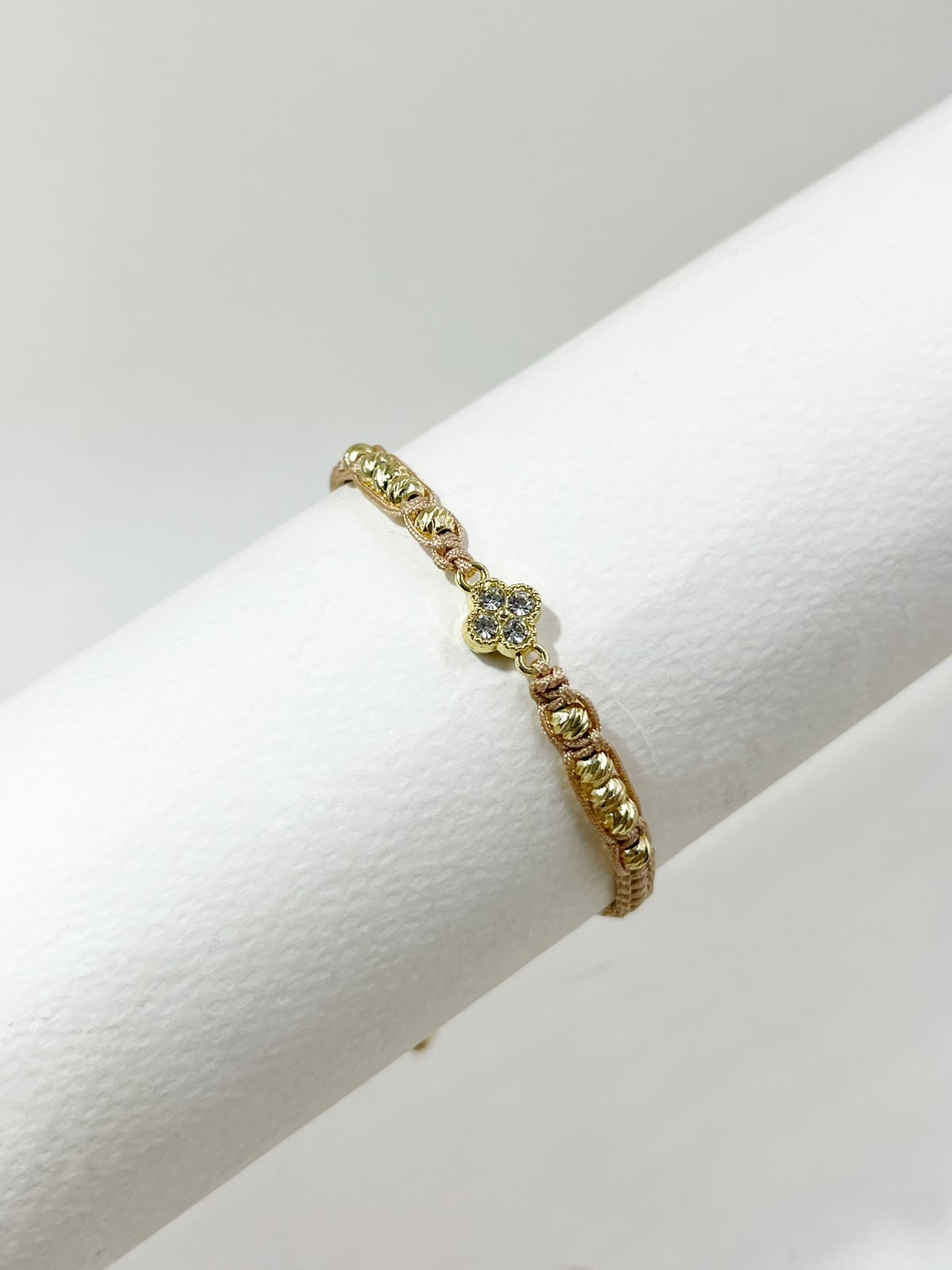 Pulsera artesanal con dije de trébol de cuatro hojas, de diseño delicado y elegante.