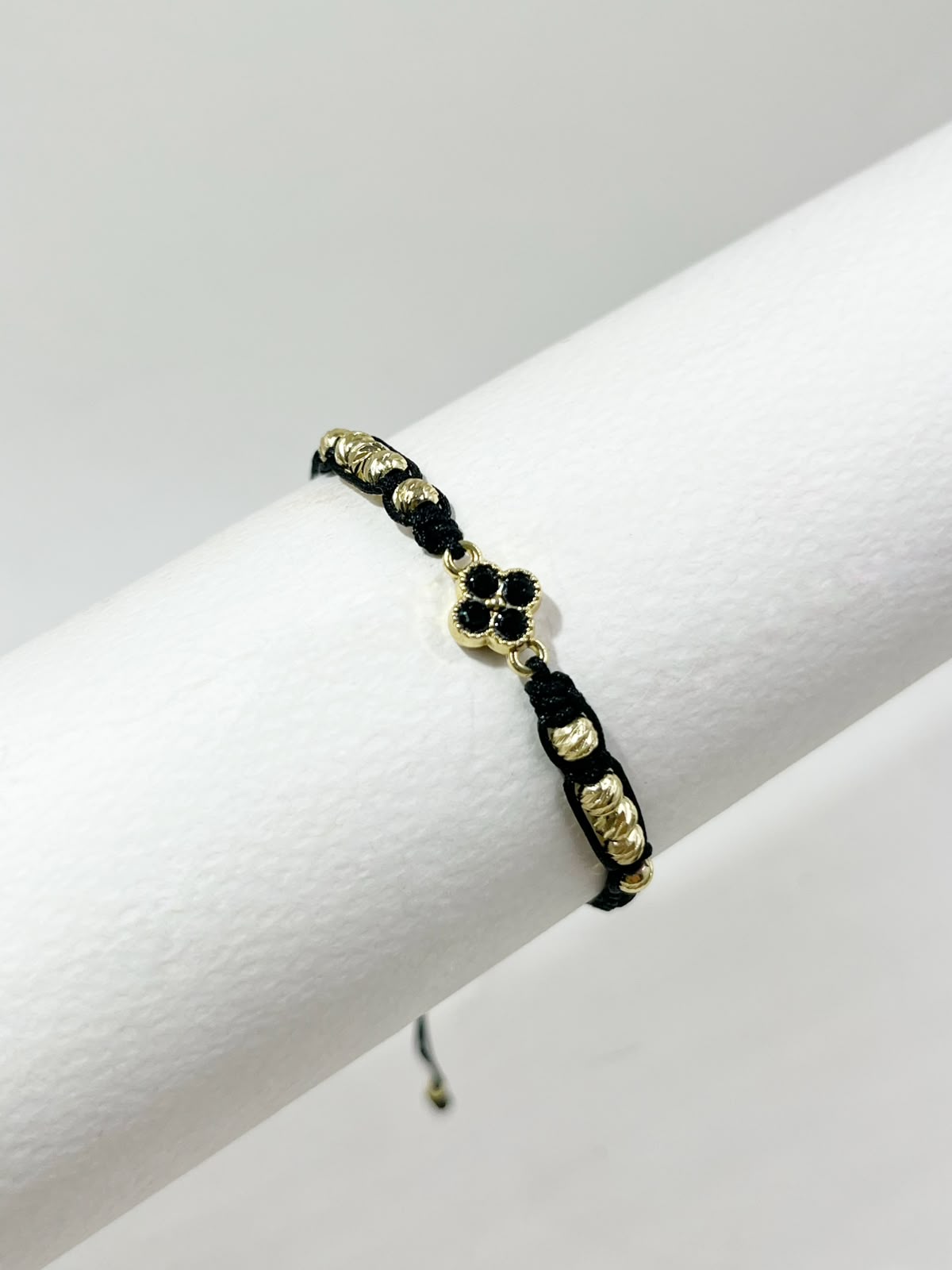 Pulsera artesanal con dije de trébol de cuatro hojas, de diseño delicado y elegante.