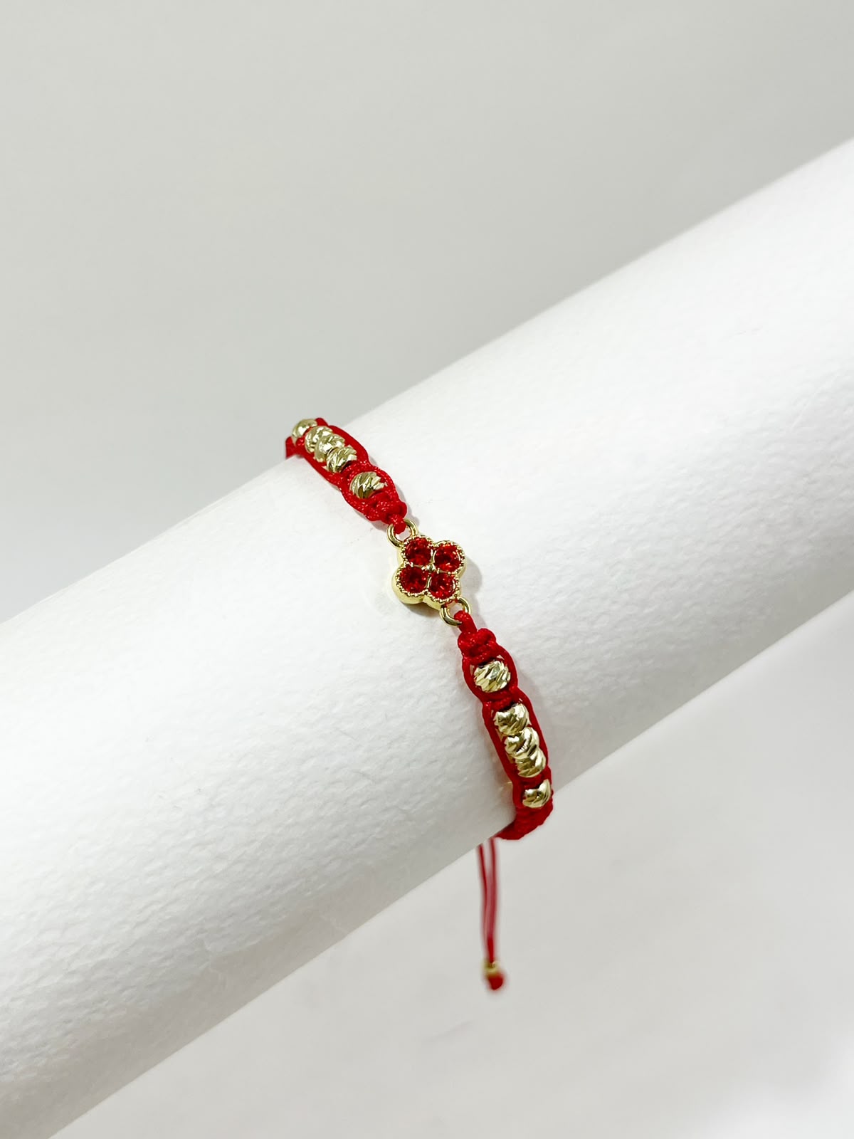 Pulsera artesanal con dije de trébol de cuatro hojas, de diseño delicado y elegante.