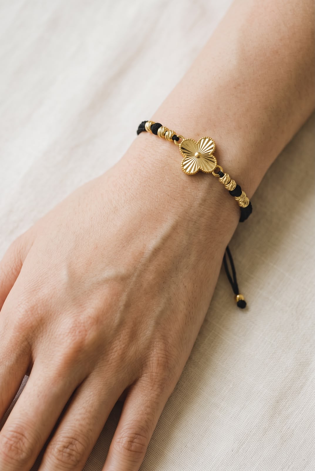 
Pulsera artesanal con dije de trébol de cuatro hojas y diseño delicado.