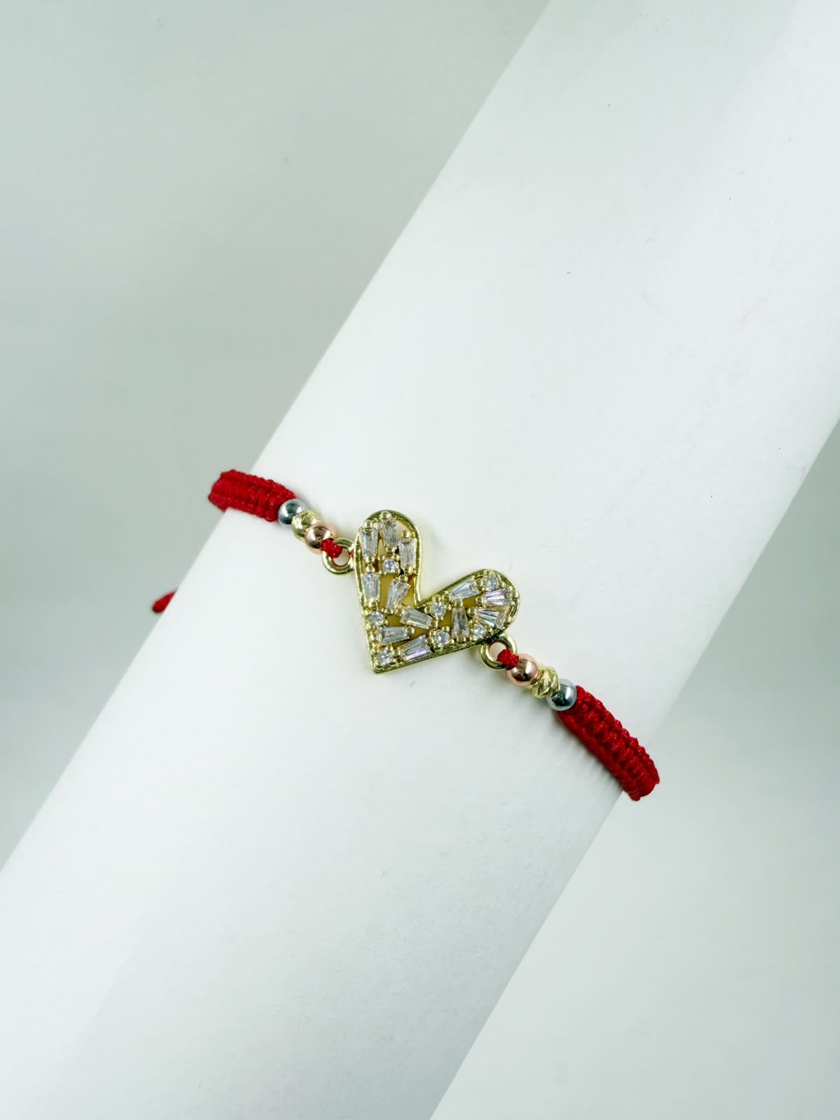 Pulsera artesanal con corazón calado decorado con detalles brillantes y diseño elegante.