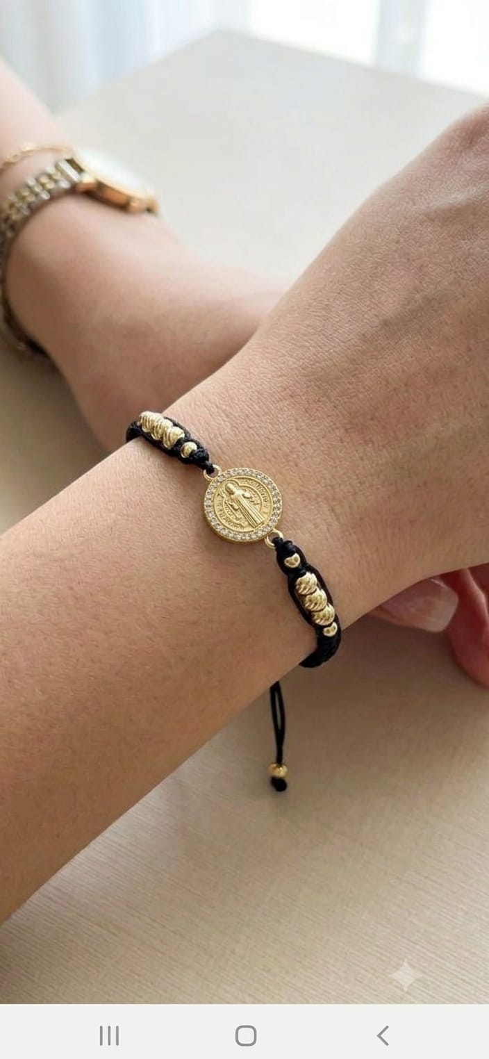 Pulsera artesanal con dije de San Benito, de diseño sencillo, delicado y elegante.