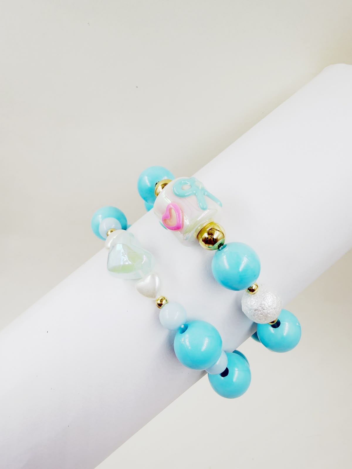 Pulsera de cuentas con corazones, perlas y detalles decorativos.