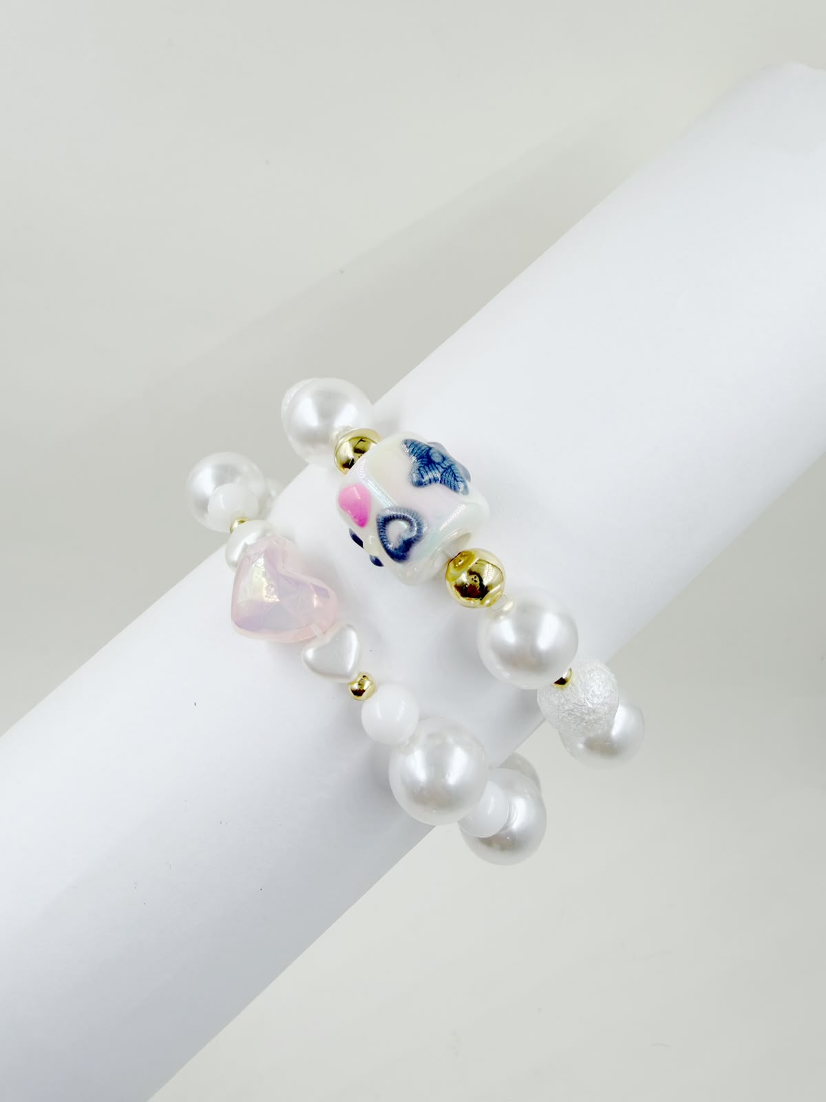 Pulsera de cuentas con corazones, perlas y detalles decorativos.