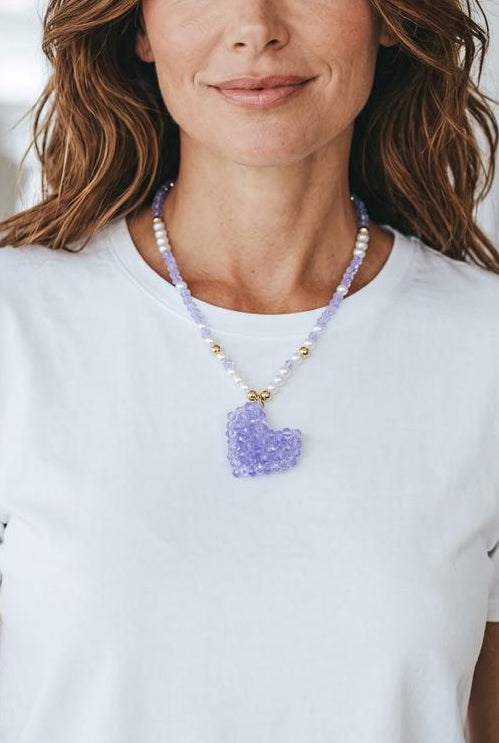 Collar artesanal con corazón de cristales facetados como dije central y detalles dorados.